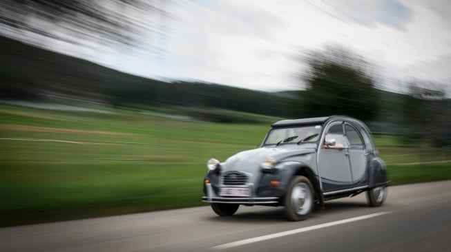 Sebuah mobil melaju ke pertemuan Dunia ke-24 Citroen 2CV Friends di dekat Delemont, Swiss, Rabu (26/7/2023). [GABRIEL MONNET/AFP]