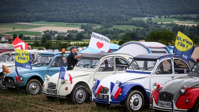 Mobil-mobil klasik terparkir berjejer di lapangan saat pertemuan Dunia ke-24 Citroen 2CV Friends di dekat Delemont, Swiss, Rabu (26/7/2023). [GABRIEL MONNET/AFP]
