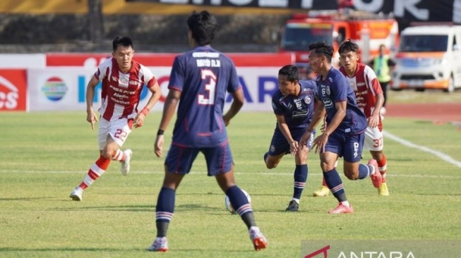 Pemain nomor punggung 22 Persis Sutanto Tan (kostum merah putih) saat menghadang serangan beberapa pemain Arema FC (kostumbiru biru) dalam Liga 1 Indonesia di Stadion Sriwedari Solo, Minggu (30/7/2023). ANTARA/Bambang Dwi Marwoto.