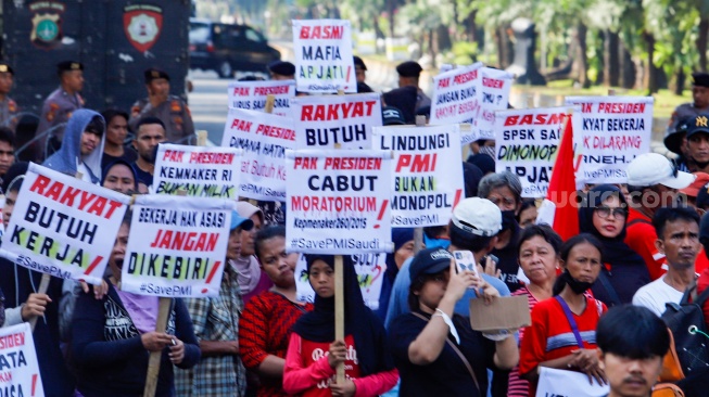 Massa yang tergabung dalam Solidaritas Perjuangan Pekerja Migran Indonesia melalukan aksi di sekitar Patung Kuda, Jakarta, Senin (31/7/2023). [Suara.com/Alfian Winanto]