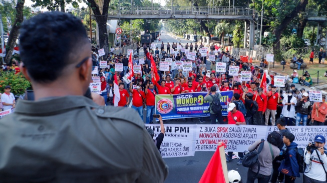 Massa yang tergabung dalam Solidaritas Perjuangan Pekerja Migran Indonesia melalukan aksi di sekitar Patung Kuda, Jakarta, Senin (31/7/2023). [Suara.com/Alfian Winanto]