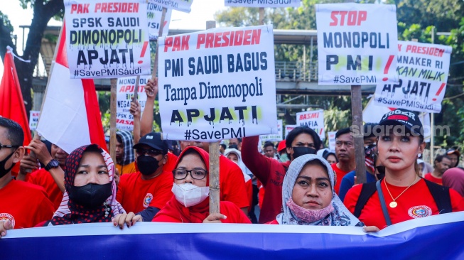 Massa yang tergabung dalam Solidaritas Perjuangan Pekerja Migran Indonesia melalukan aksi di sekitar Patung Kuda, Jakarta, Senin (31/7/2023). [Suara.com/Alfian Winanto]