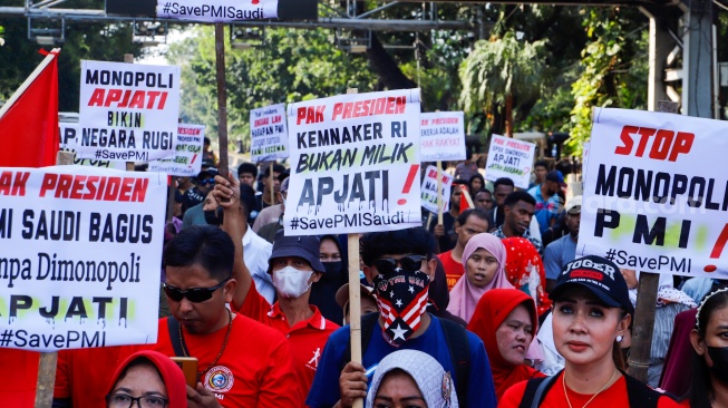 Massa yang tergabung dalam Solidaritas Perjuangan Pekerja Migran Indonesia melalukan aksi di sekitar Patung Kuda, Jakarta, Senin (31/7/2023). [Suara.com/Alfian Winanto]