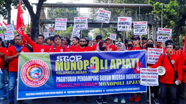 Massa yang tergabung dalam Solidaritas Perjuangan Pekerja Migran Indonesia melalukan aksi di sekitar Patung Kuda, Jakarta, Senin (31/7/2023). [Suara.com/Alfian Winanto]