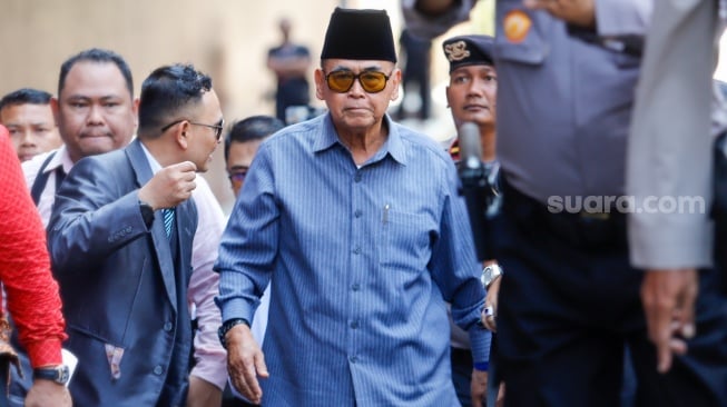 Pimpinan Pondok Pesantren Al Zaytun Panji Gumilang (tengah) berjalan saat akan menjalani pemeriksaan di Bareskrim Mabes Polri, Jakarta, Selasa (1/8/2023). [Suara.com/Alfian Winanto]