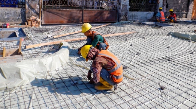 Pekerja saat menyelesaikan revitalisasi trotoar di kawasan Blok M, Jakarta Selatan, Selasa (1/8/2023).  [Suara.com/Alfian Winanto]