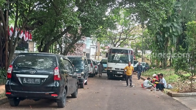 Akses menuju rumah Guruh Soekarnoputra ditutup oleh mobil pribadi dan bus Suara.com/Rena Pangesti]