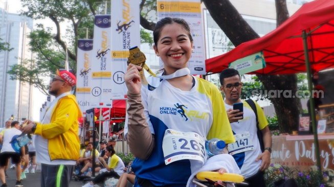 Peserta menunjukkan medali usai mengikuti gelaran Hukumonline Run 2023 di kawasan SCBD, Jakarta, Minggu (6/8/2023). [Suara.com/Alfian Winanto]