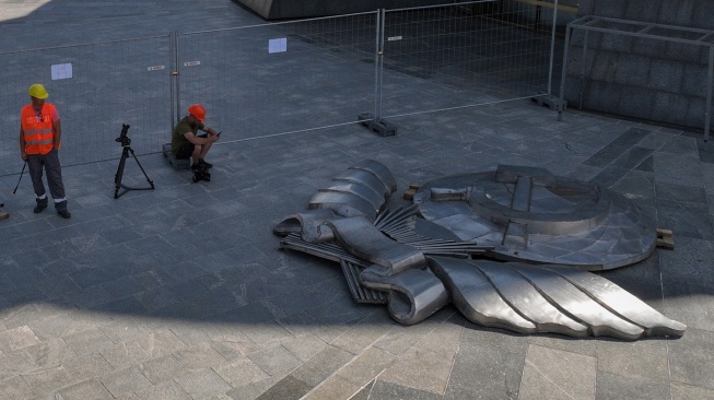 Para pekerja duduk di dekat pecahan lambang bekas Uni Soviet yang telah dibongkar dari perisai Monumen Ibu Pertiwi di Kyiv, Ukraina, Selasa (1/8/2023). [Sergii VOLSKYI/AFP]