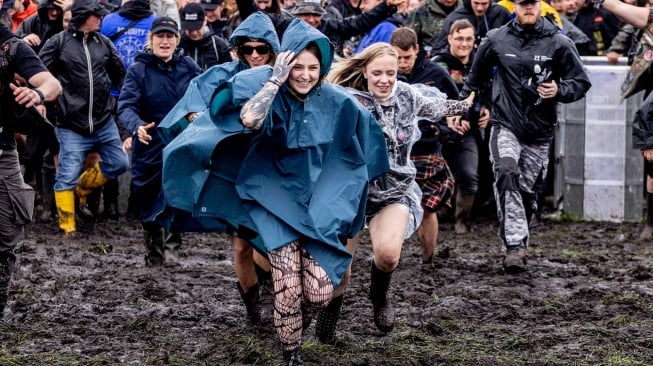 Para metalhead bersorak riang saat pembukaan festival musik Wacken Open Air 2023 di Wacken, Jerman, Rabu (2/8/2023). [Axel Heimken / AFP] 