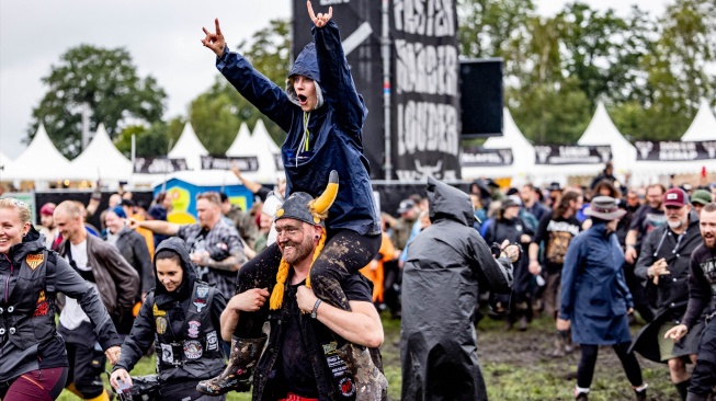 Para metalhead bersorak riang saat pembukaan festival musik Wacken Open Air 2023 di Wacken, Jerman, Rabu (2/8/2023). [Axel Heimken / AFP] 