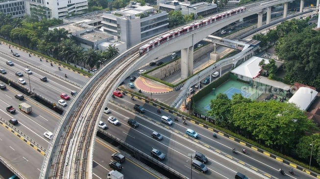 Kereta ringan atau Light Rail Transit (LRT) melintas di jembatan rel lengkung (longspan) LRT Kuningan, Jakarta, Senin (7/8/2023). [Suara.com/Alfian Winanto]