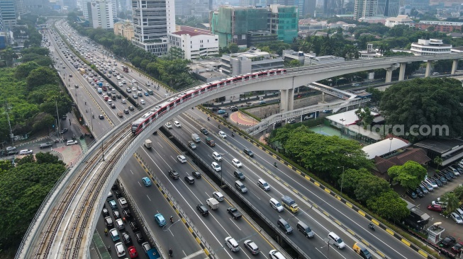 Kereta ringan atau Light Rail Transit (LRT) melintas di jembatan rel lengkung (longspan) LRT Kuningan, Jakarta, Senin (7/8/2023). [Suara.com/Alfian Winanto]