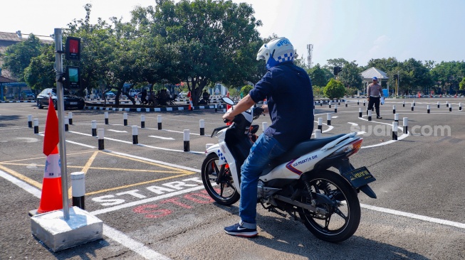 Peserta mengendarai sepeda motor saat ujian praktik SIM C di Satpas Polda Metro Jaya, Jalan Daan Mogot, Jakarta, Selasa (8/8/2023). [Suara.com/Alfian Winanto]
