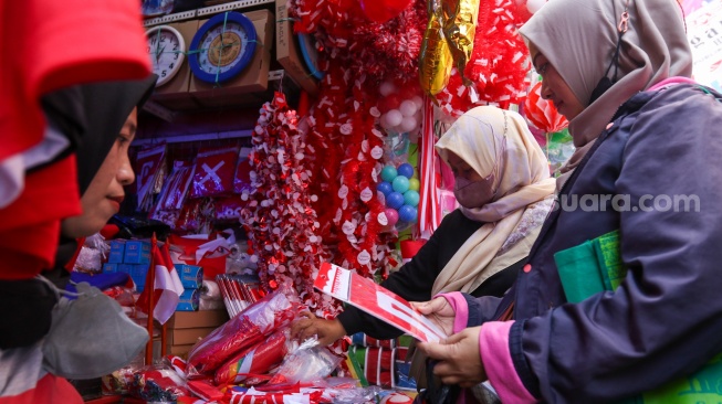 Warga memilih pernak-pernik merah putih untuk HUT RI ke-78 di Kawasan Pasar Mester Jatinegara, Jakarta, Selasa (8/8/2023). [Suara.com/Alfian Winanto]