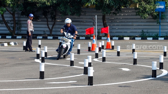 Peserta mengendarai sepeda motor saat ujian praktik SIM C di Satpas Polda Metro Jaya, Jalan Daan Mogot, Jakarta, Selasa (8/8/2023). [Suara.com/Alfian Winanto]