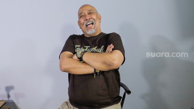 Aktor Indro Warkop berpose saat berkunjung ke Kantor Suara.com di Kuningan, Jakarta, Rabu (9/8/2023). [Suara.com/Alfian Winanto]