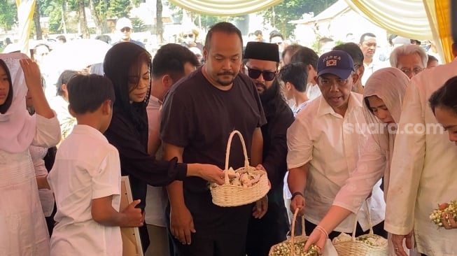 Kikan Cokelat didampingi suami tampak berduka dan tak bisa membedung kesedihan, saat mengikuti acara pemakaman sang ibu di TPU Jeruk Purut, Jakarta Selatan, Rabu (9/8/2023). [Adiyoga Priyambodo/Suara.com]