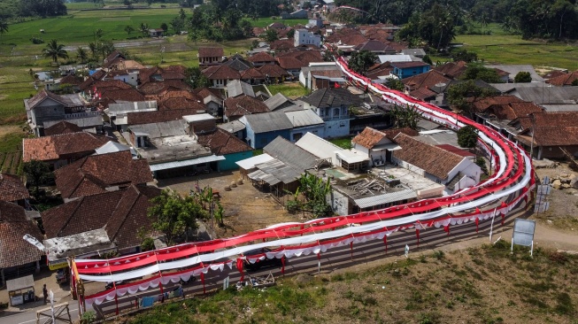 Foto udara lorong bendera Merah Putih bertema Terus Melaju untuk Indonesia Maju yang terbentang di Desa Sukamenak, Kabupaten Tasikmalaya, Jawa Barat, Sabtu (12/8/2023). [ANTARA FOTO/Adeng Bustomi/tom]
