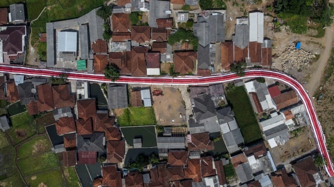 Foto udara lorong bendera Merah Putih bertema Terus Melaju untuk Indonesia Maju yang terbentang di Desa Sukamenak, Kabupaten Tasikmalaya, Jawa Barat, Sabtu (12/8/2023). [ANTARA FOTO/Adeng Bustomi/tom]
