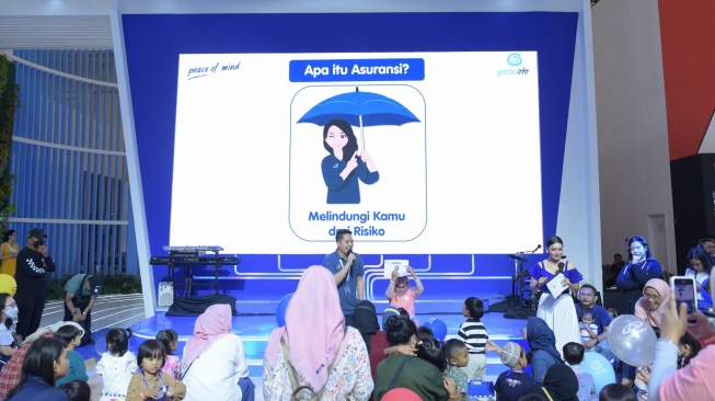 Branch Manager Asuransi Astra, Daniel Febrian saat sedang membawakan literasi dan edukasi keuangan dengan metode story telling kepada anak-anak dengan rentang usia 3 hingga 10 tahun di kelas Little Financial Master & Emergency Roadside Assistance Tour di GIIAS Tangerang, ICE, BSD pada 12 Agustus 2023 [Asuransi Astra].