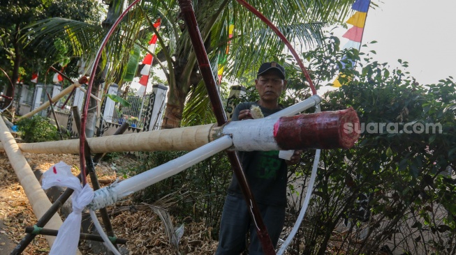 Pengrajin mengerjakan tahapan pembuatan batang  panjat pinang di kawasan, Manggarai, Jakarta, Senin (14/8/2023). [Suara.com/Alfian Winanto]