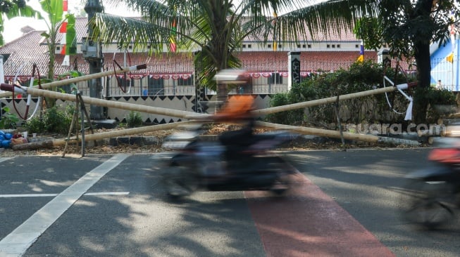 Pengrajin mengerjakan tahapan pembuatan batang  panjat pinang di kawasan, Manggarai, Jakarta, Senin (14/8/2023). [Suara.com/Alfian Winanto]