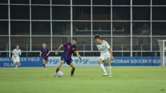 Kapten Barcelona Nill Caldero Soteres (kiri) berusaha mengamankan bola dari pemain Real Madrid dalam partai final International Youth Championship di Lapangan I Gusti Ngurah Rai, Denpasar, Bali, Senin (14/8/2023) malam. ANTARA/Rolandus Nampu