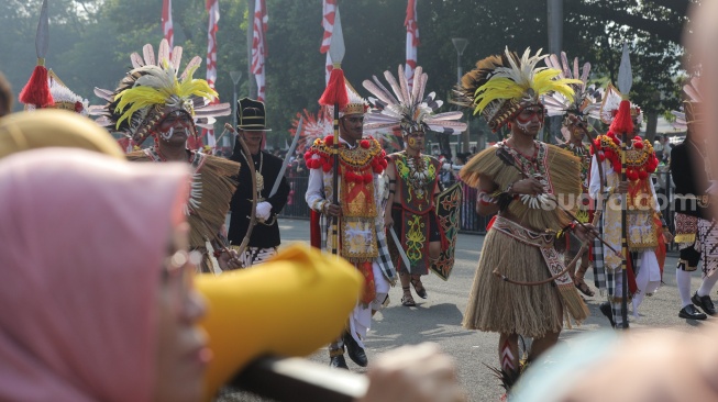 Sejumlah peserta Kirab Bendera Pusaka memakai baju adat berjalan menuju Istana Merdeka di Jakarta, Kamis (17/8/2023). [Suara.com/Alfian Winanto]