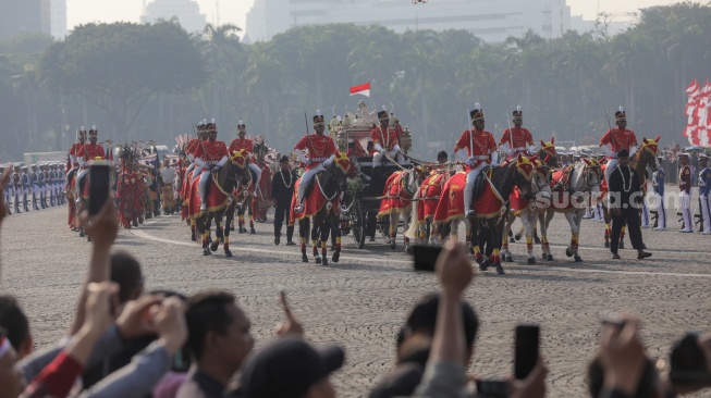 Pasukan berkuda mengiringi Kereta kencana yang membawa duplikat bendera pusaka merah putih dan teks proklamasi saat Kirab Bendera Pusaka menuju Istana Merdeka di Jakarta, Kamis (17/8/2023). [Suara.com/Alfian Winanto]