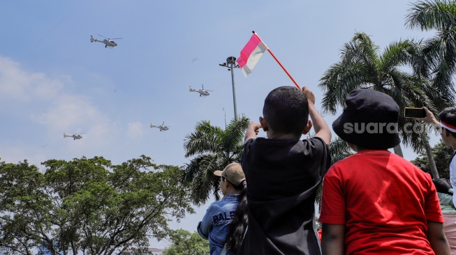 Warga melihat atraksi udara di atas langit Jakarta, Kamis (17/8/2023). [Suara.com/Alfian Winanto]