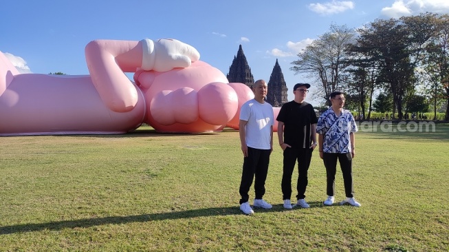 Seniman kelas dunia, KAWS, turut membuka pameran KAWS:HOLIDAY di Candi Prambanan, Yogyakarta, Jumat (18/8/2023). (Suara.com/Rima Sekarani I.N.)