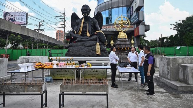 Para pejabat dan otoritas setempat berkumpul di depan patung raksasa dewa Kru Kai Kaew di Bangkok, Thailand, Jumat (18/8/2023). [Lillian SUWANRUMPHA / AFP]
