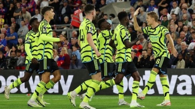 Martin Odegaard (kanan) merayakan golnya dari titik penalti bersama pemain Arsenal lainnyam pada pertandingan sepak bola Liga Utama Inggris antara Crystal Palace dan Arsenal di Selhurst Park di London selatan pada 21 Agustus 2023. Adrian DENNIS / AFP