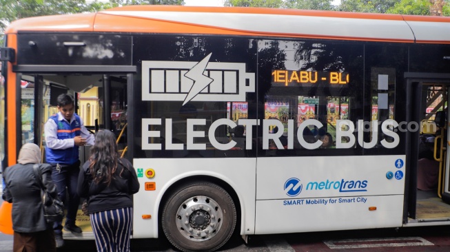 Penumpang menaiki bus listrik Transjakarta melintas di kawasan Bulungan, Jakarta, Selasa (22/8/2023). [Suara.com/Alfian Winanto]