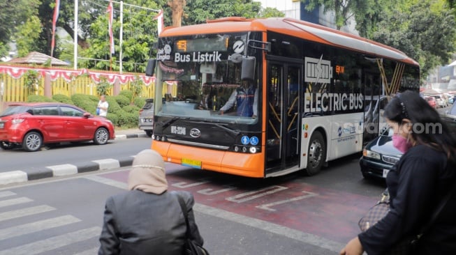 Penumpang menaiki bus listrik Transjakarta melintas di kawasan Bulungan, Jakarta, Selasa (22/8/2023). [Suara.com/Alfian Winanto]
