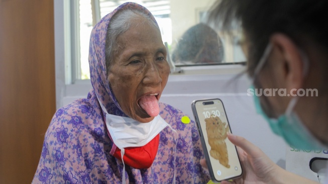 Pasien dengan gejala batuk dan sesak antre memeriksakan diri di Poli Batuk dan infeksi saluran pernapasan akut (ISPA) di Puskesmas Mampang Prapatan, Jakarta, Rabu (23/8/2023). [Suara.com/Alfian Winanto]