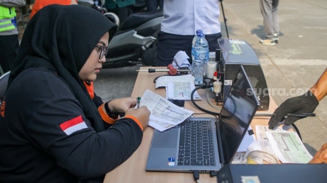 Petugas melakukan uji emisi kendaraan bermotor di Terminal Blok M, Jakarta Selatan, Jumat (25/8/2023). [Suara.com/Alfian Winanto]