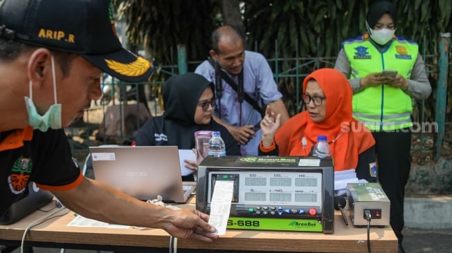 Petugas melakukan uji emisi kendaraan bermotor di Terminal Blok M, Jakarta Selatan, Jumat (25/8/2023). [Suara.com/Alfian Winanto]