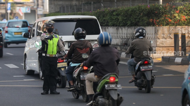 Petugas kepolisian menghentikan kendaraan bermotor untuk uji emisi di Terminal Blok M, Jakarta Selatan, Jumat (25/8/2023). [Suara.com/Alfian Winanto]