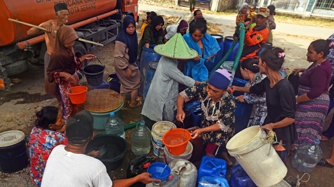 Petugas Badan Penanggulangan Bencana Daerah (BPBD) Kota Serang membagikan air bersih untuk warga terdampak kekeringan di Kampung Kacacang, Sawahluhur, Serang, Banten, Sabtu (26/8/2023). [ANTARA FOTO/Asep Fathulrahman/tom]