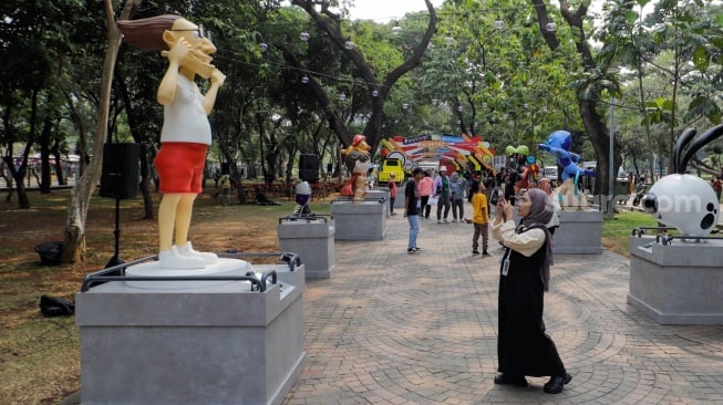 Pengunjung melihat sejumlah karya yang dipamerkan pada Festival Karakter Kekayaan Intelektual (FKKI) di Taman Monas Sisi Selatan, Jakarta, Sabtu (26/8/2023). [Suara.com/Alfian Winanto]