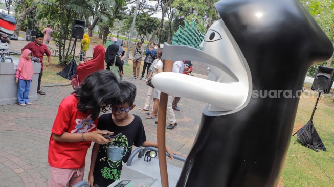 Pengunjung melihat sejumlah karya yang dipamerkan pada Festival Karakter Kekayaan Intelektual (FKKI) di Taman Monas Sisi Selatan, Jakarta, Sabtu (26/8/2023). [Suara.com/Alfian Winanto]