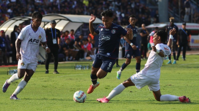 Pesepak bola Persik Kediri Yusuf Meilana Fuad (kanan) berebut bola dengan pesepak bola Arema Fc Arkha Fikri (tengah) pada pertandingan Liga 1 di Stadion Brawijaya, Kota Kediri, Jawa Timur, Sabtu (15/7/2023). ANTARA FOTO/Prasetia Fauzani/nym.