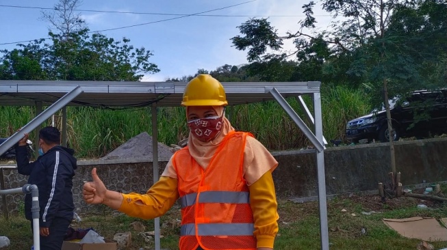 Umi dengan latar belakang PLTS Serut 2 [Dokumen Pribadi]