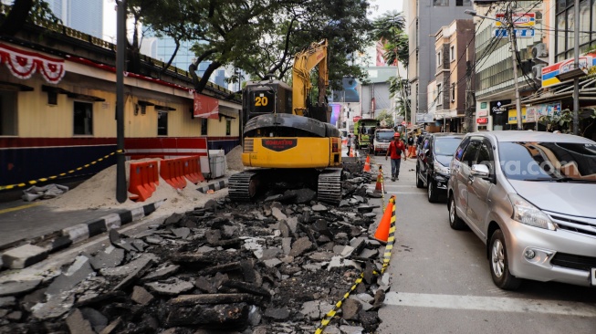 Pekerja menyelesaikan proyek pembangunan jalur pedestrian di Jalan Blora, Jakarta Pusat, Kamis (31/8/2023). [Suara.com/Alfian Winanto]