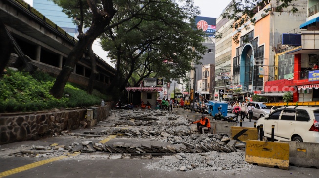 Pekerja menyelesaikan proyek pembangunan jalur pedestrian di Jalan Blora, Jakarta Pusat, Kamis (31/8/2023). [Suara.com/Alfian Winanto]