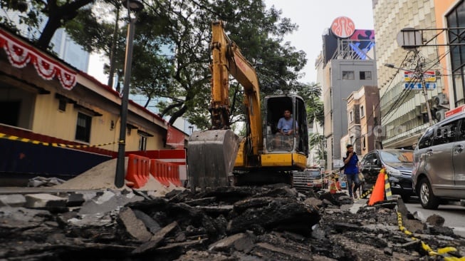 Pekerja menyelesaikan proyek pembangunan jalur pedestrian di Jalan Blora, Jakarta Pusat, Kamis (31/8/2023). [Suara.com/Alfian Winanto]