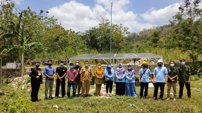 Umi bersama tim dan perwakilan dari warga setempat dan pemerintah berfoto dengan latar PLTS Serut [Dokumen Pribadi]