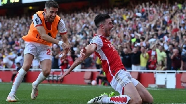 Gelandang Arsenal Declan Rice melakukan selebrasi setelah mencetak gol kedua mereka di menit-menit akhir selama pertandingan sepak bola Liga Utama Inggris antara Arsenal dan Manchester United di Stadion Emirates di London pada 3 September 2023. Glyn KIRK / AFP